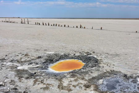 Crystallized salt and natural mineral mud in a dried salt lake. Here people take mud baths because of the benefits of sulfur. Natural background. Dried up salt lake. lake with healing mudの写真素材