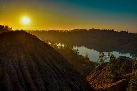yellow dawn over a lake in a flooded quarry, Romance mountains