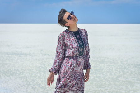 woman in dress on a white salt lake, portrait of a woman on a white salt lake. woman in hat and...