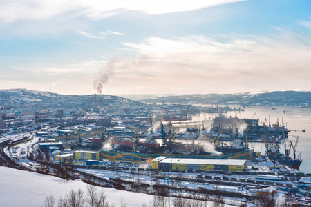 Murmansk, Russia - March 7, 2021: top view of the docks and the unfrozen sea against the backdrop of mountainsのeditorial素材