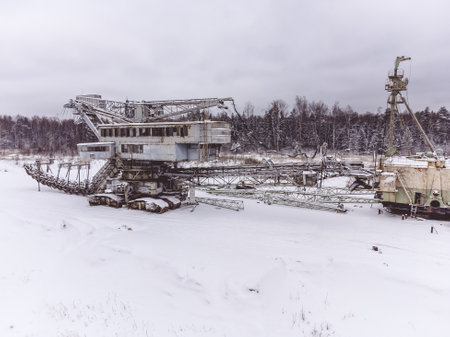 abandoned giant bucket wheel excavator stands in a field in winterの写真素材