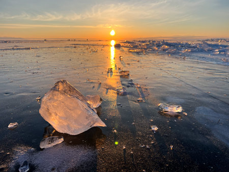 Winter landscape of frozen lake Baikal on a sunny February day. Beautiful blue smooth ice with...