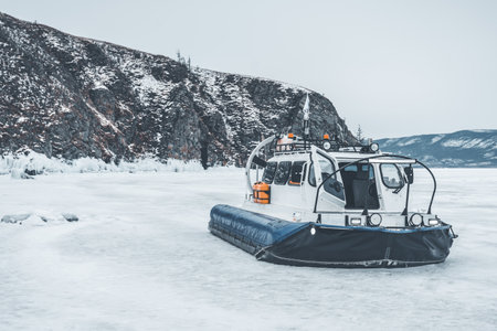A white boat is on the water in the snow. The boat is moving and the water is frozenの写真素材