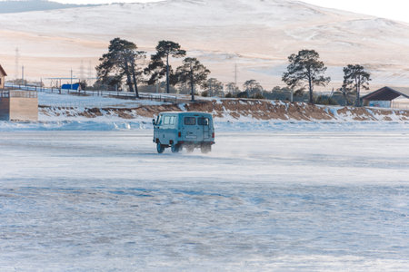 A white van is driving on a snowy road. The scene is peaceful and serene, with the snow-covered...