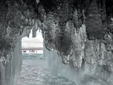 A large ice formation with a blue sky in the background. The ice formation is very large and has a lot of icicles hanging from it. The sky is clear and blue, with no clouds in sightの写真素材
