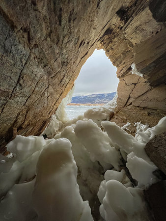 A large ice formation with a blue sky in the background. The ice formation is very large and has a lot of icicles hanging from it. The sky is clear and blue, with no clouds in sightの写真素材