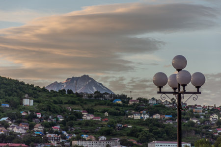 City with a mountain in the background. The mountain is covered in snow. The city is full of buildings and housesの写真素材