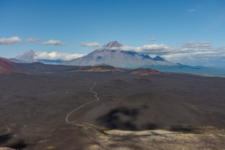 Mountain range with a large mountain in the middle. Slag fields with a volcano in the background