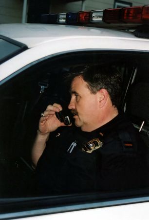 Police officer in car talking on telephone.の写真素材