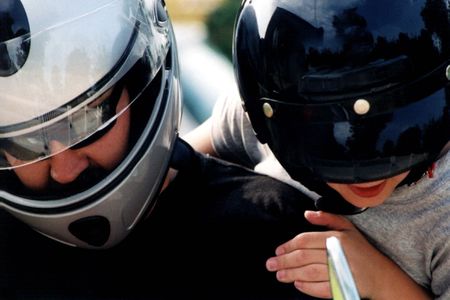 Closeup of father and sun getting on a motorcycle.の写真素材