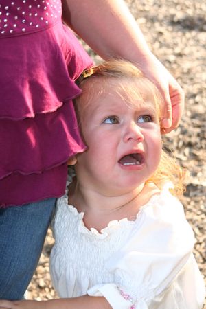Little girl crying at her mother's side.の写真素材