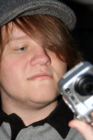 Teen boy checking picture he took on a point and shoot digital camera.
