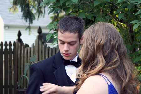 Prom Girl Brushes Off Date's Tuxedo With Handの写真素材