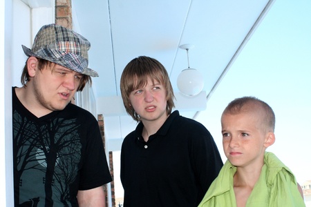 Three brothers, two teenagers and one adolescent, with anxious expressions.の写真素材