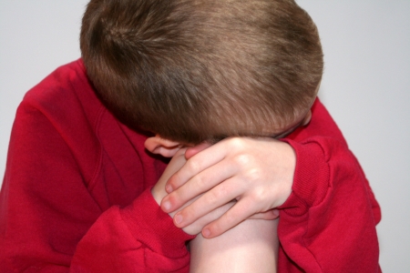 Sad Anonymous Boy Closeup Leaning Against Kneeの写真素材
