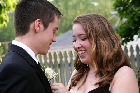 Laughing Prom Girl Fixing Boutonniereの写真素材