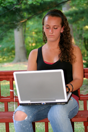 Teen Girl Behind Laptop Outdoors (Vertical)の写真素材