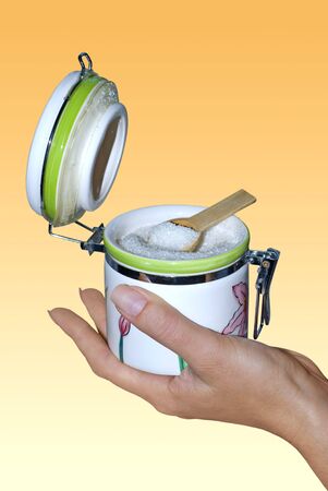 spoon and opened white sugar bowl on handの写真素材