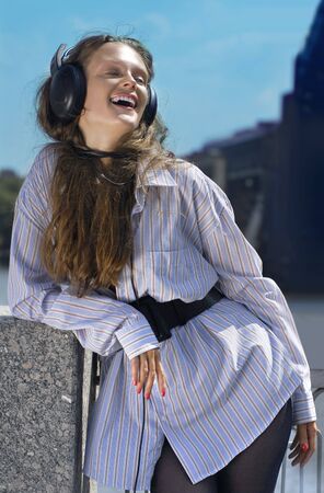 Happy girl is listening music on the quay luck outの写真素材