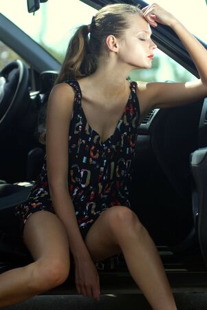 fashionable young beautiful sad woman in a car の写真素材
