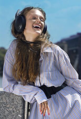 Happy girl is listening music on the quay luck outの写真素材
