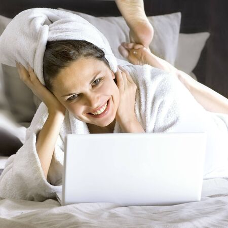 happy business lady on the bed with laptopの写真素材