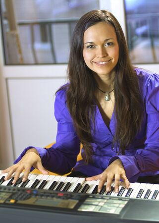 happy young pianist with sequencer on a studioの写真素材
