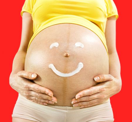 closeup body of pregnant woman on which smile is drawnの写真素材