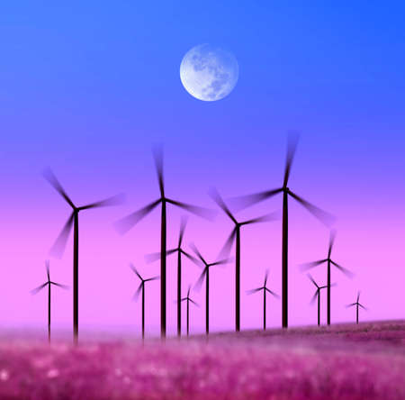 silhouette of wind turbines generating electricity on night skyの写真素材