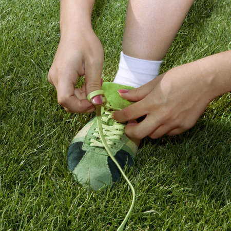 girl ties laces on the sports shoesの写真素材