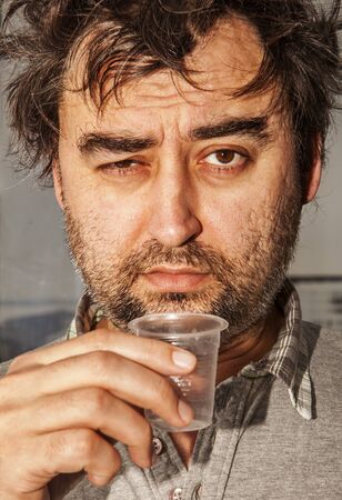 the face of drunkard without fixed place of residence, a cardboard dwellerの写真素材