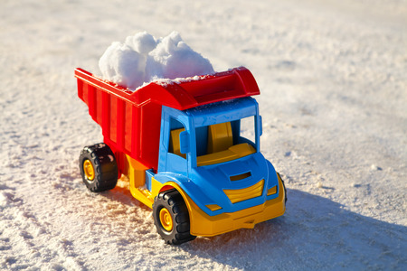 toy truck removes snow on the road in winterの写真素材