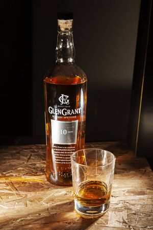 LVIV, UKRAINE - DECEMBER 04: Bottle of Glen Grant whisky and glass on wooden shelf on December 04, 2017 in Lvivのeditorial素材