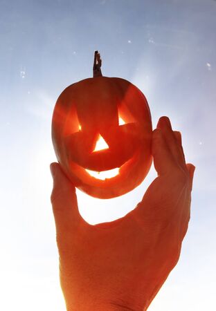 Happy pumpkin like monster in a hand for Halloweenの写真素材