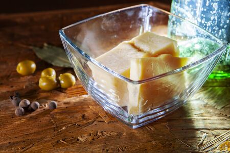 Slices of parmesan cheese and spices on the kitchen tableの写真素材