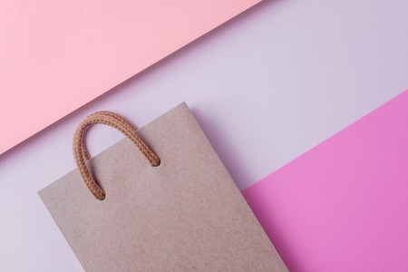 Craft paper shopping bag on paper textured backdrop. Use copy space for sale and store design. Consumer concept.の写真素材