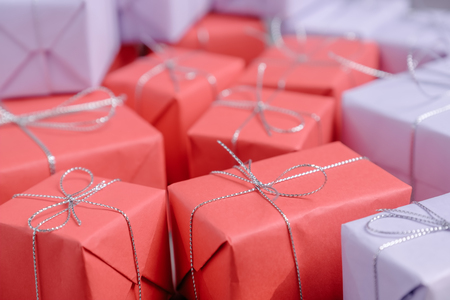 Lots of mixed gifts wrapped in red and lilac paper and tied withの写真素材