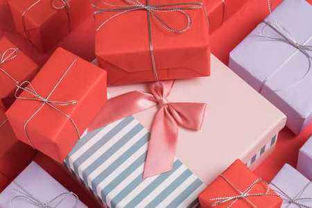 Lots of small mixed gifts wrapped in red and lilac paperの写真素材
