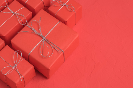 The heap of presents wrapped in red craft paperの写真素材