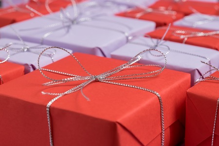 Presents wrapped in red and lilac paper as festive backgroundの写真素材
