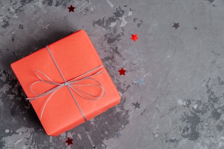 One handcrafted festive presents wrapped in red paperの写真素材