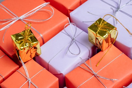 Presents on top of gifts wrapped in red and lilac paperの写真素材