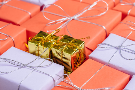 Two small golden colored presents on top of giftsの写真素材