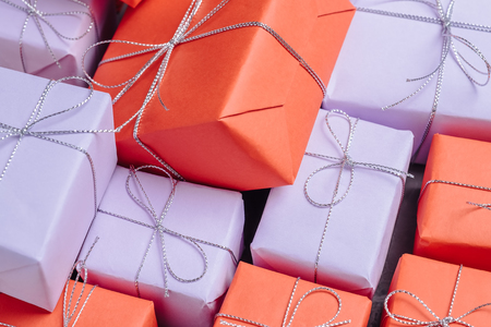 Festive presents wrapped in red and lilac paper and tied with siの写真素材