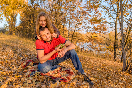 In the autumn park near the river. Concept of parenting and happy family.の写真素材