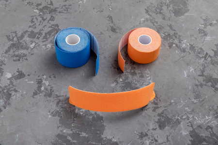 two rolls colored kinesio tape and stripe as smileの写真素材