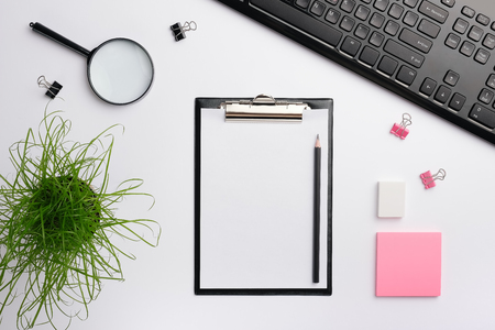 black clipboard mockup. Home office desk workspace with black keyboard, sticker, eraser and other office accessories. Flat lay, copy space, top viewの写真素材