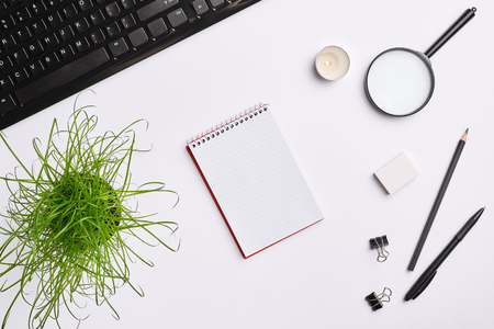 Home office workspace with black keyboard, notebook, candle, pen, plant and other office accessories. Flat lay, copy space, top viewの写真素材