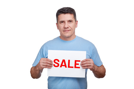 Senior man holds paper sheet with word sale in two hands and smiling. Copy space for textの写真素材