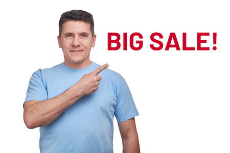 Handsome smiling middle-aged man pointing on text big saleの写真素材